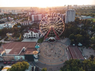 Kharkiv şehir merkezinde günbatımında dönen dönme dolap Maxim Gorky 'nin eğlence parkı. Eğlence ve şehir gözlemi için yüksek çekim