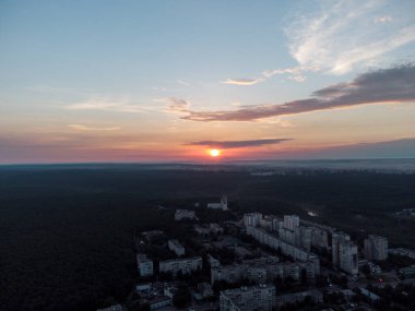 Hava manzaralı Kharkiv şehri Pavlove Pole bölgesi. Karanlık orman, çok katlı evler ve gündoğumu gökyüzü