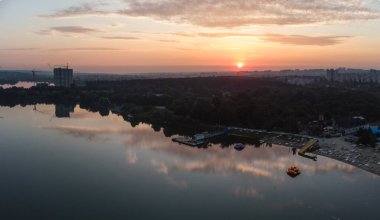 Geniş nehir üzerinde yansıyan su yüzeyine yansıyan bulutların olduğu manzaralı hava gündoğumu. Sabahın erken saatlerinde, Kharkiv Zhuravlivsky Hidropark plajında gökyüzünden. Drone fotoğrafçılığı
