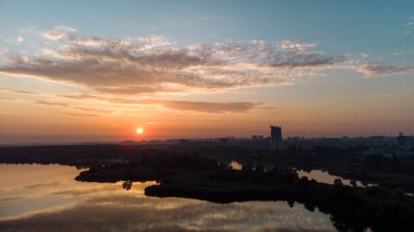 Geniş nehir üzerinde yansıyan su yüzeyine yansıyan bulutların olduğu manzaralı hava gündoğumu. Sabahın erken saatlerinde, Kharkiv Zhuravlivsky Hidropark 'ta gökyüzünden. Drone fotoğrafçılığı