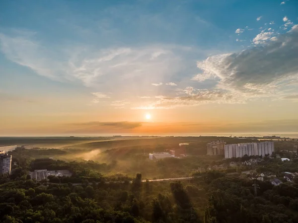 Havadan gün doğumu bulutlu gökyüzü. Şafak vakti güzel pastel ışıkta çok katlı binalar ve sisli yeşillikler. Harkiv 'de Sarzhyn Yar köprüsü ile Sokilnyky' ye bak.