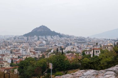 Lycabettus Dağı ve Atina 'nın eski şehir merkezinde Areopagus' tan gelen gri sisli yaz günü - Akropolis yakınlarındaki tepe