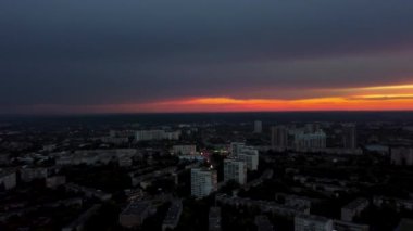 Sağdan sola doğru hava aksamı bulutlu dramatik günbatımı gökyüzü ile şehre doğru panoramik bir manzara. Şehir sokaklarının üzerinde akşam uçuşu. Kharkiv, Ukrayna şehir merkezi parkı ve yerleşim bölgesi