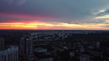 Şehrin çok katlı yerleşim bölgesinde destansı canlı günbatımı manzarası. 23 Serpnia, Pavlovo Pole, Kharkiv, Ukrayna. Dramatik akşam bulutları ve şehir sokaklarıyla geriye doğru uç.