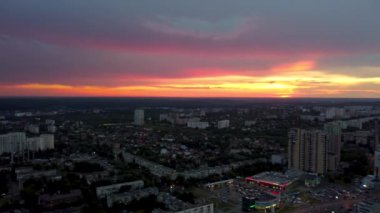 Şehrin yerleşim bölgesindeki dramatik, canlı günbatımı manzarası. 23 Serpnia, Pavlovo Pole, Kharkiv, Ukrayna. Görkemli akşam gökyüzü, bulutlar ve binaların siluetleri ile soldan sağa uç