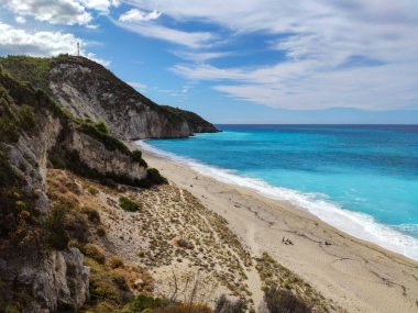 Yunanistan 'ın Lefkada adasının kıyısında, gök mavisi, parlak dalgalı Mylos kumlu plajı. İyon Denizi 'ne yaz tatili