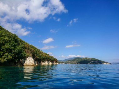 Yunanistan 'ın İyon Denizi' ndeki Lefkada adasındaki güzel kayalık çakıl taşı plajı. Parlak, berrak, mavi su, yaz manzarası.