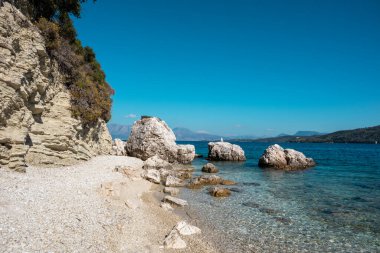 Yunanistan 'ın Lefkada adasında kayalık uçurumları ve masmavi suları olan beyaz çakıl taşı plajı. Yaz vahşi doğa seyahati İyon Denizi 'ne