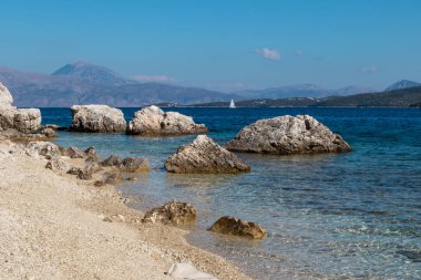Yunanistan 'ın Lefkada adasının açık deniz kıyısında beyaz çakıl taşları ve kayalıklar. Yaz vahşi doğa seyahati İyon Denizi 'ne