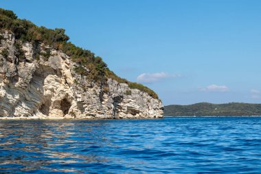 Kayalık beyaz uçurumları ve berrak gökyüzü olan İyon Denizi 'nin mavi canlı suları. Yunanistan 'daki Lefkada adasının doğası. Yaz tatilinde gidilecek yer