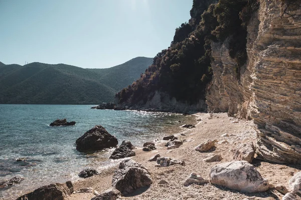 Yunanistan 'ın Lefkada adasında kayalık uçurumları ve berrak suları olan beyaz güneşli çakıl taşı plajı. Yaz vahşi doğa İyon Denizi 'ne seyahat eder. Renk sınıflandırılmış