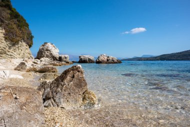 Yunanistan 'ın Lefkada adasının açık deniz kıyısında kumsalda beyaz çakıl taşları ve kayalar. İyon Denizi 'ne yaz tatili