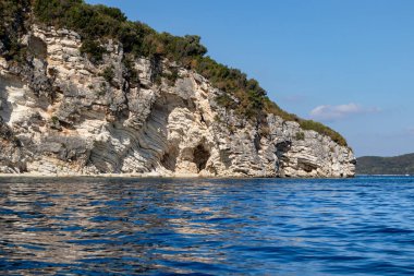 Kayalık beyaz uçurumları ve parlak gökyüzü olan İyon Denizi 'nin mavi yansıtıcı suyu. Yunanistan 'daki Lefkada adasının doğası. Yaz seyahati