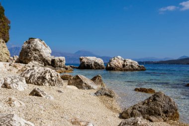 Beyaz çakıl taşları ve kayalıklar, Yunanistan 'ın Lefkada adasının açık deniz kıyısında yakın çekim yapıyorlar. Yaz vahşi doğa seyahati İyon Denizi 'ne