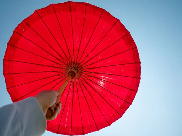 Ombrello sulla mano della donna contro il sole cielo blu — Foto Stock