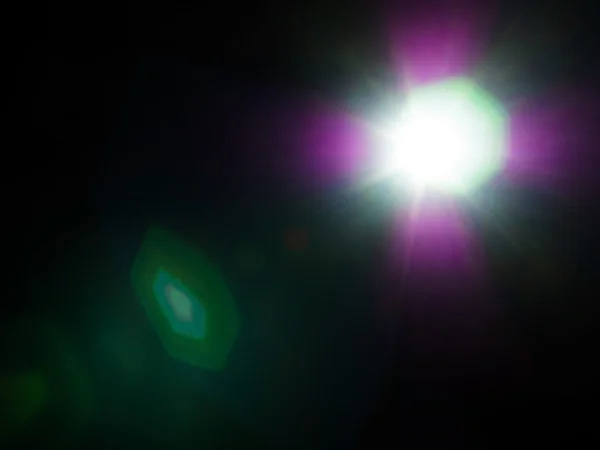 Lens flare van sterke lichtbron in het donker — Stockfoto