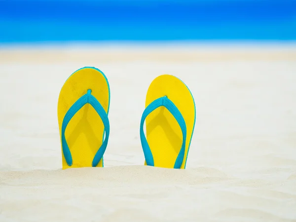 Tongs jaunes sandales pieds dans le sable — Photo