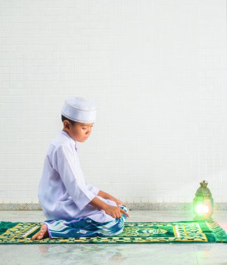 Müslüman çocuk Allah 'a ibadet eder ve dua eder.