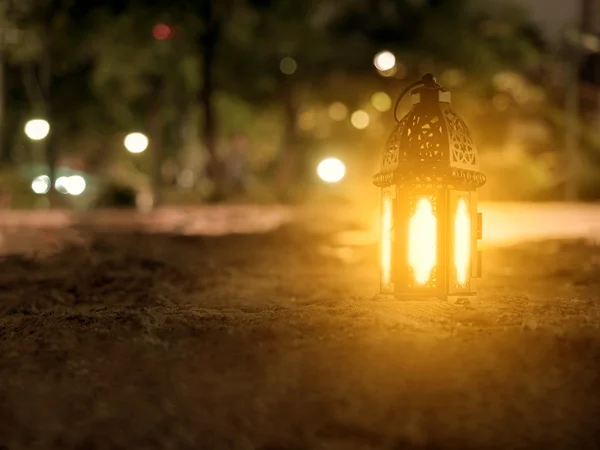 Verlichting met kaars binnen lantaarn stralend op zand vloer playgr — Stockfoto