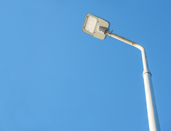 Уличная лампа на голубом фоне неба