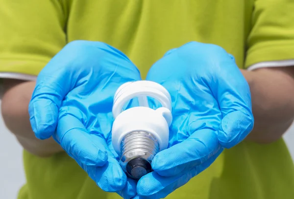 Kompaktfluoreszenz auf blauem Handschuh — Stockfoto