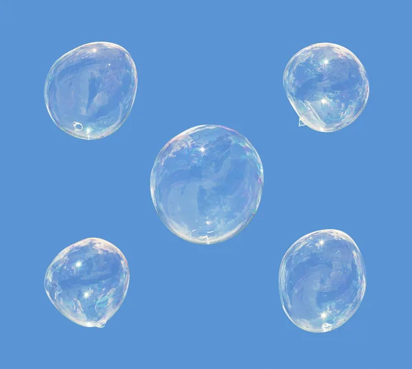 Cinco bolhas de sabão isoladas em azul — Fotografia de Stock