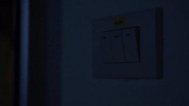 Adamın parmak pozisyonu kapalı olarak aydınlatma anahtarı işletim