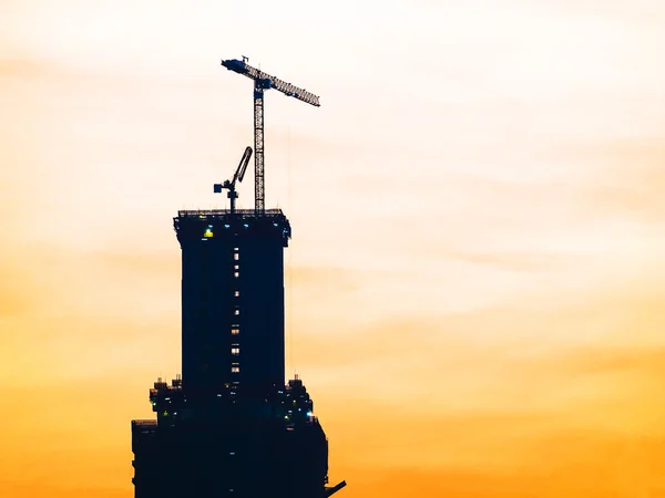 Construction site with silhouette crane — Stock Photo, Image