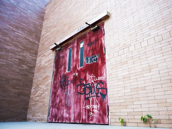 Puerta roja envejecida en la pared de ladrillo —  Fotos de Stock