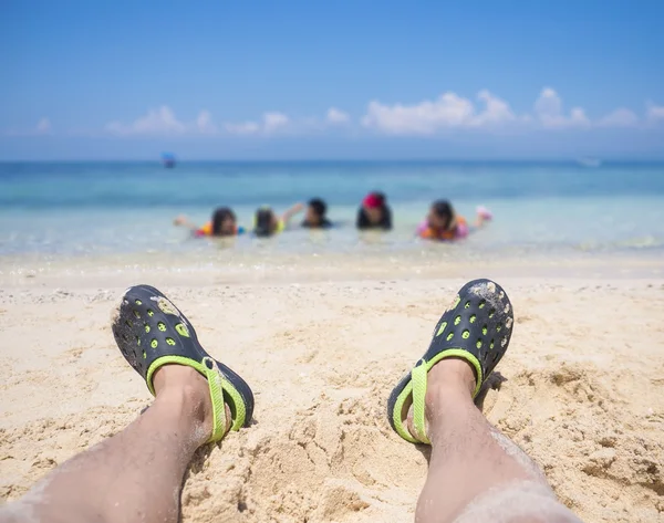 Pie en zapatillas en la playa de arena blanca —  Fotos de Stock