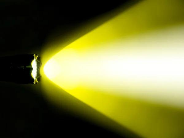 暗闇の中で懐中電灯の黄色のライト — ストック写真