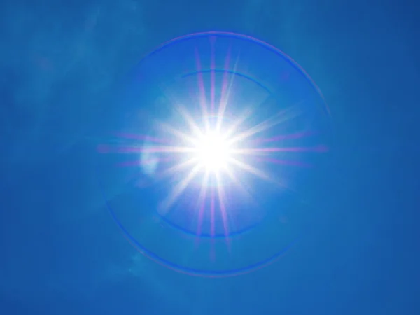 Lente di 12mm bagliore del sole su cielo blu — Foto Stock