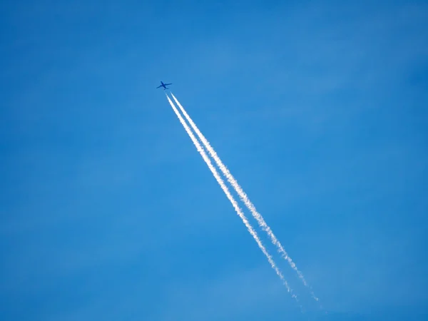 エアコン跡を作って空を横切って飛んでいる飛行機 — ストック写真