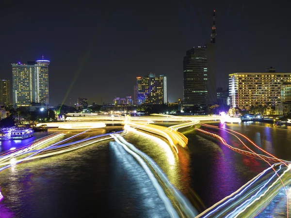 Движение в реке на фоне ночного горизонта города — стоковое фото