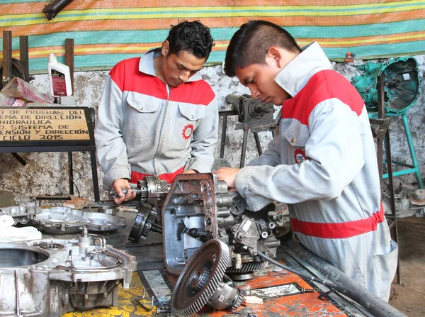 Dos estudiantes de mecánica con piezas de automóviles en Perú — Foto de Stock