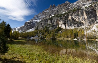 Dolomitlerde sonbahar, dağlarla çevrili Federa gölü manzarası.