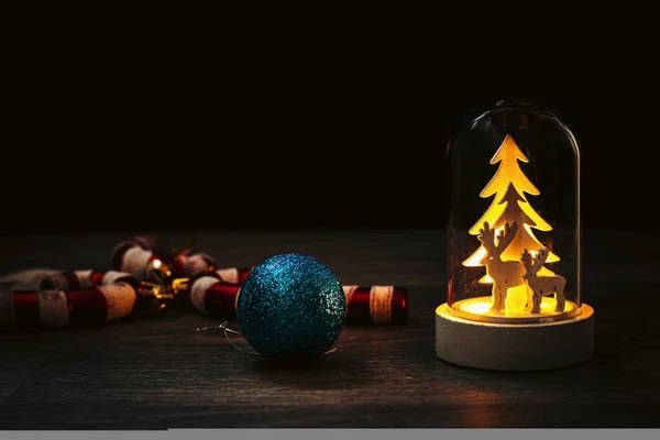 장식용 장식으로 어두운 배경에 조명이 유리통 장식용 가문비나무와 사슴이 크리스마스 — 스톡 사진