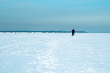 Yaşlı bir adam donmuş bir nehrin yüzeyinde kayak yapıyor. Sağlıklı yaşam tarzı