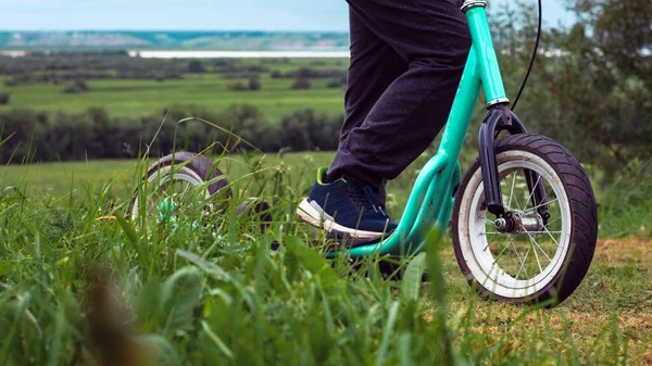 Pés Criança Uma Scooter Com Rodas Grandes Entre Grama Verde — Fotografia de Stock