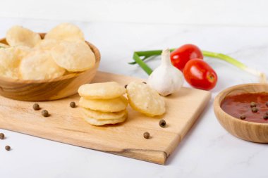 Beyaz bir masa ve ahşap tabakta Hint yemeği.