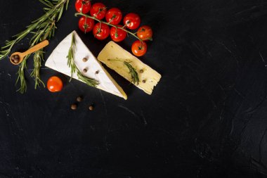 Siyah arkaplanda kiraz domatesli peynir.