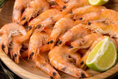 Limonlu haşlanmış karides ve ahşap bir kasede dereotu.