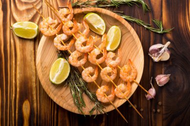 Tahta masadaki şişte karides.