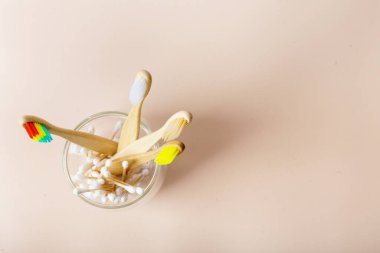 Cam bardakta bej arka planda bambu diş fırçaları. Gurur Ayı - Bambu Gökkuşağı Diş fırçası - Diş fırçanı sev - Dişlerini fırçala