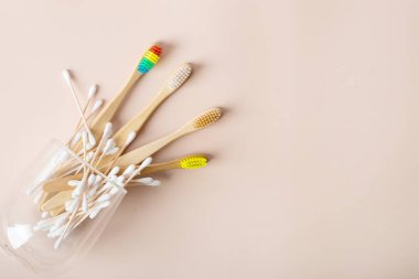 Cam bardakta bej arka planda bambu diş fırçaları. Gurur Ayı - Bambu Gökkuşağı Diş fırçası - Diş fırçanı sev - Dişlerini fırçala