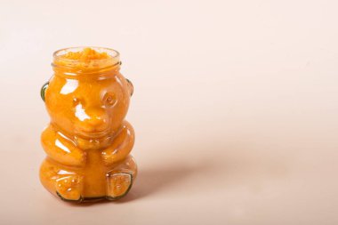 Beyaz üzerinde havuç ve kaşık olan bir kavanoz bebek püresi. bebek havuç püresi