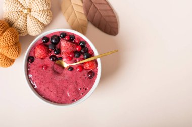 Balkabağı, muz ve şeftalili vejetaryen smoothie soya sütü, susam tohumu, sonbahar meyveli smoothie örgü kabaklı bir masada.