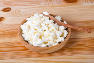 Ahşap arka planda taze süzme peynir, yakın plan. Köy peyniri ahşap bir masada.