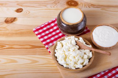 süzme peynir, süt ve ekşi krema ahşap bir masada. Ekşi krema