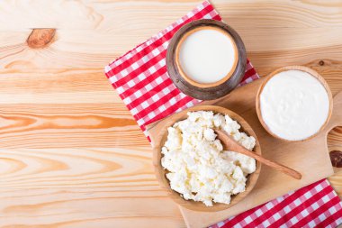 süzme peynir, süt ve ekşi krema ahşap bir masada. Ekşi krema